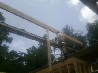 Carpenter setting a ridge beam over a new addition frame — Ice Dam Removal by Roofing Brothers in Pipestone