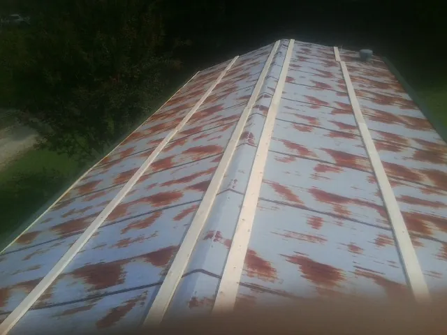 Rusted metal roof panels with new wood purlins before replacement — Storm Damage Roof Repair in Pipestone by Roofing Brothers