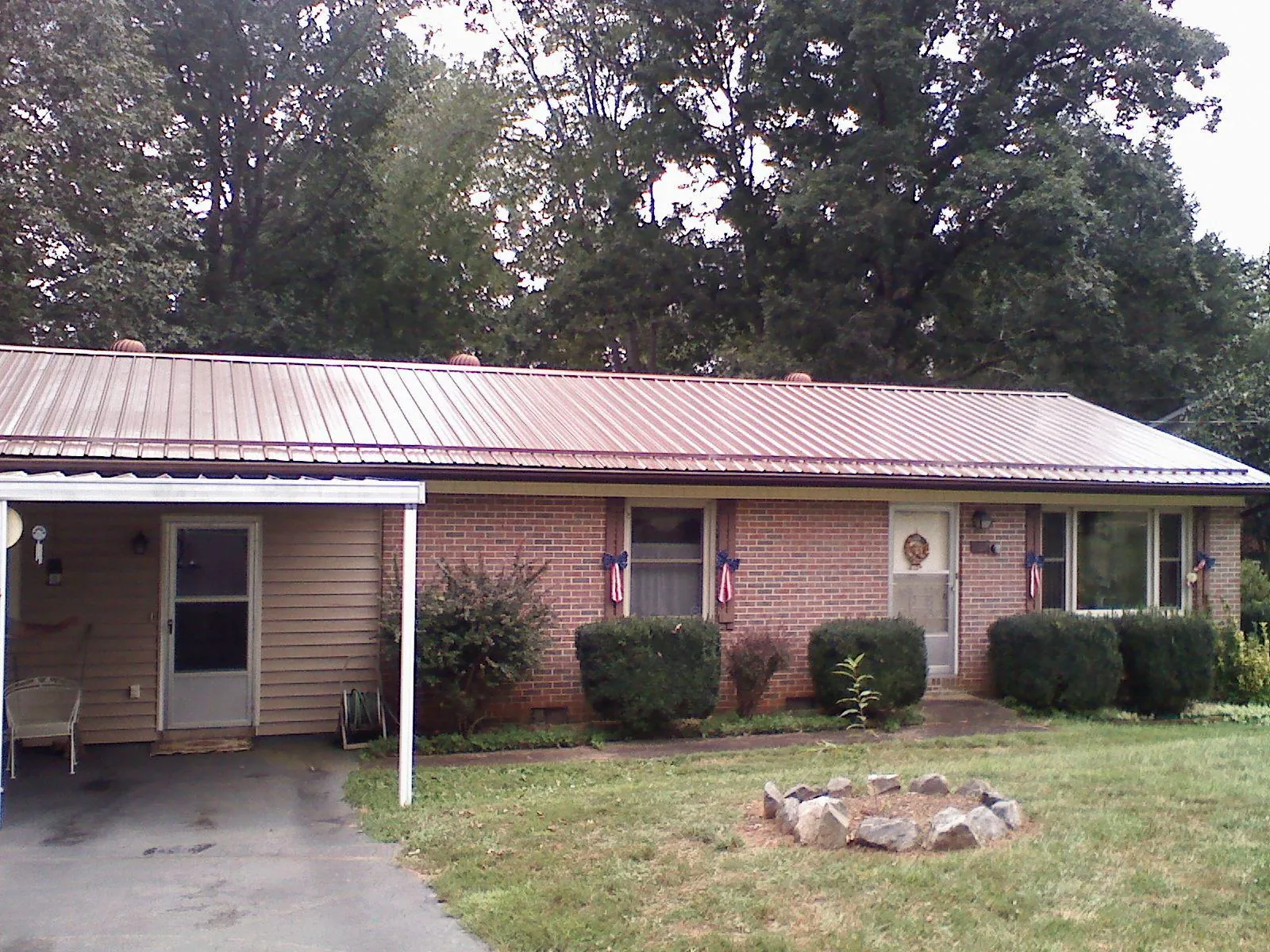Bronze metal roof and carport on a brick ranch home — Roof Repair work by our crew in Pipestone