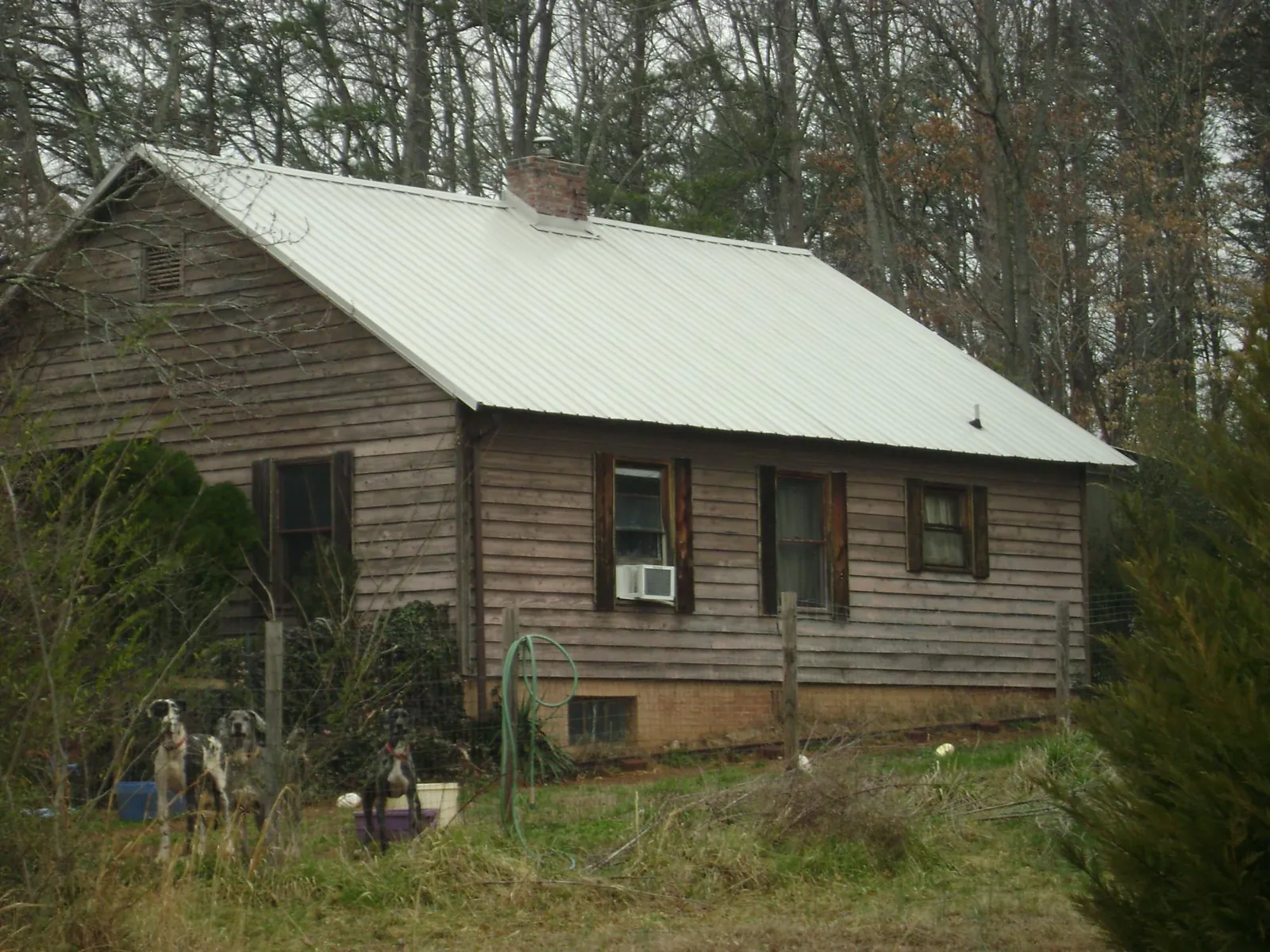 White metal roof on an old wood sided farmhouse, from a Metal Roof Installation job in Pipestone